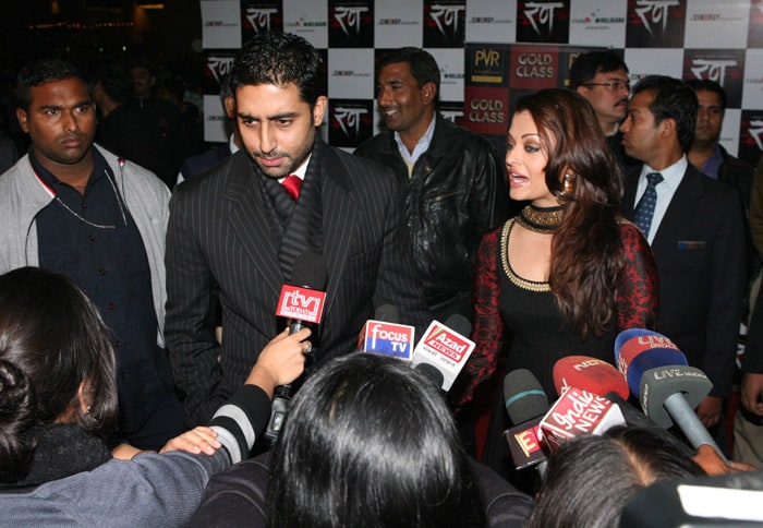 Abhishek Bachchan speaks to the media at the premiere of <i>Rann</i> as his wife Aishwarya looks on. (Photo: NDTV)