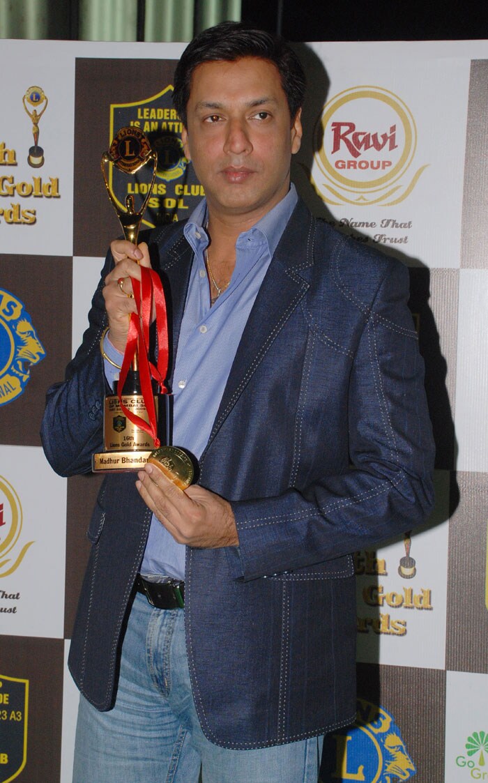 Filmmaker Madhur Bhandarkar holding his award at the event.