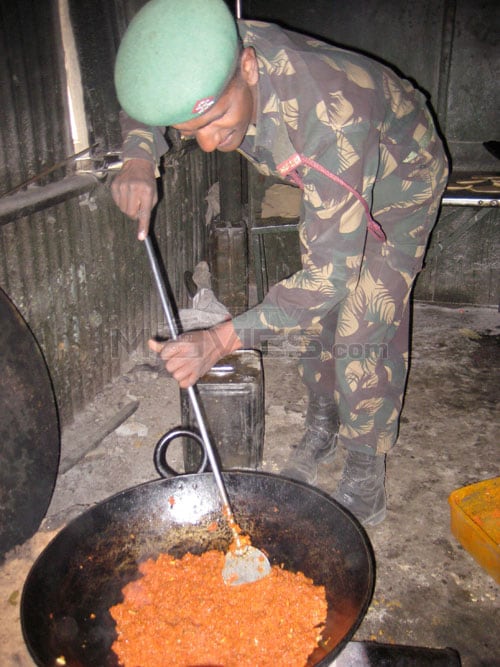 A jawan heating the halwa that Abhishek has got for them.