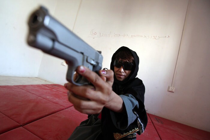 In this picture taken on June 7, 2010, a female member of the Afghan National Police (ANP) aims a 9mm pistol as she attends a training session in Kandahar city. In the heart of the violent city of Kandahar, birthplace of the Taliban movement, some women have resorted to taking up arms -- against the advice of their families and society -- to join the risky ranks of the ANP. (Photo: AFP)