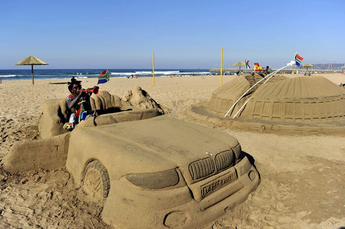 A South African blows his vuvuzela while siting on a sand sculpture depicting a BMW on the beach of Durban on June 7, 2010 less than a week before the start of the 2010 World Cup football tournament. (Photo: AFP)