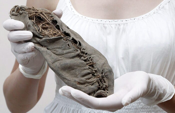 An Armenian girl displays a just-found 5,500-year leather moccasin said to be the world's oldest leather shoe in Yerevan on June 11, 2010. Proving fashion changes little over time, the shoe may be the ancestor to 'pampooties' worn in Ireland only half a century ago. The perfectly preserved cow-hide shoe, 1,000 years older than Egypt's Great Pyramid of Giza, is a moccasin-like piece in a single piece of leather shaped to fit the wearer's foot. (Photo: AFP)