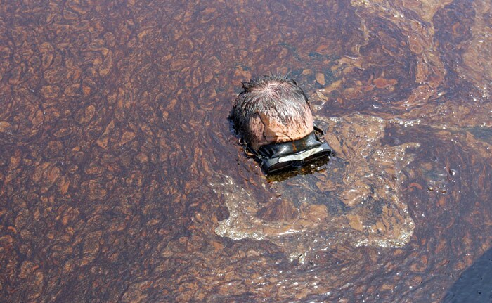 In this Monday, June 7, 2010 photo, APTN photographer Rich Matthews takes a closer look at oil from the Deepwater Horizon spill, in the Gulf of Mexico south of Venice, La.. (Photo: AP)