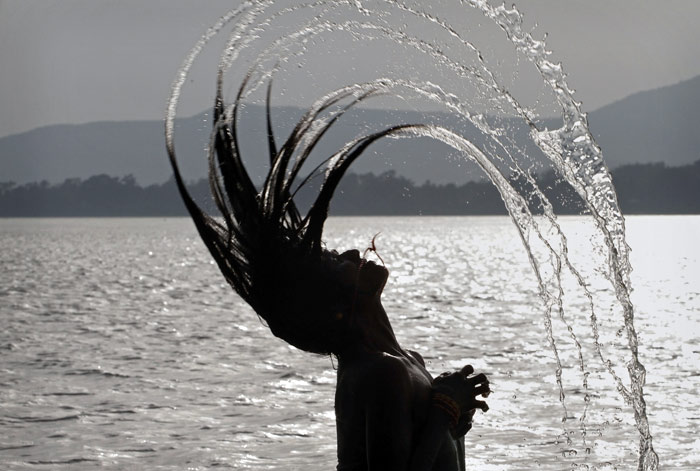 A woman throws her wet hair back as she bathes in the River Brahmaputra in Guwahati, Assam, on Monday, June 7, 2010. (Photo: AP)