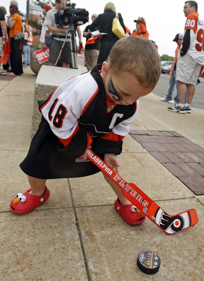 Patrick Sweeney, 2, of Holland, Pa., plays with a hockey puck on the concrete outside during a pep rally for the Philadelphia Flyers at the Wachovia Center prior to Game 6 of the Stanley Cup Finals between the Flyers and the Chicago Blackhawks in Philadelphia, Pa., on Wednesday, June 9, 2010. (Photo: AP)