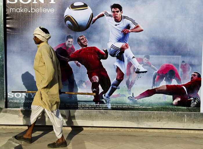 A man walks past an advertisement board promoting the FIFA World Cup 2010 outside a shop in New Delhi on June 9, 2010. (Photo: AFP)