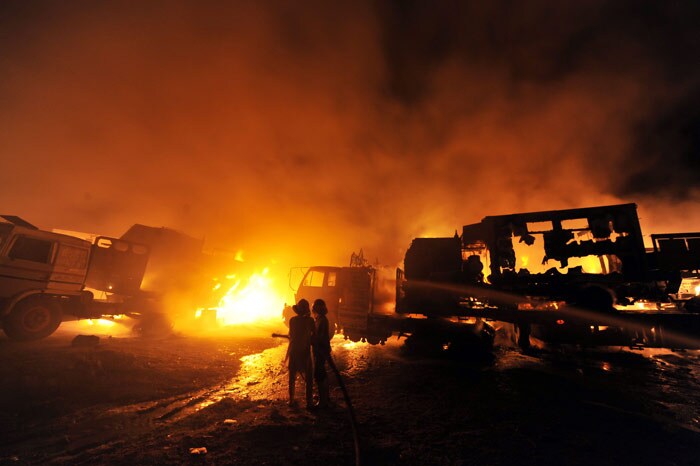 Pakistani fire fighters try to extinguish burning NATO supply trucks carrying military vehicles and oil following militants attack on the outskirts of Islamabad on June 9, 2010. Armed militants attacked a terminal near the Pakistan's capital of Islamabad on late on June 8, torching dozens trucks carrying military vehicles and oil used to supply fuel to NATO forces in Afghanistan, officials said. (Photo: AFP)