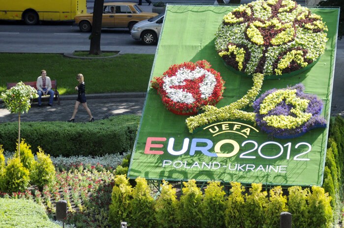 A woman walks past a flowerbed in the logo of the EURO 2012 football championships in Lviv on June 9, 2010. Lviv is the third of the eight host cities to unveil its official logo for UEFA EURO 2012 and its own tournament flowerbed, bearing the finals' distinctive bloom emblem, as Poland and Ukraine mark two years to go until the finals kick off. (Photo: AFP)