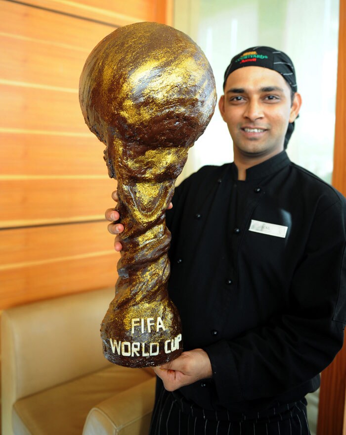 Marriott Courtyard Executive Chef Sunil Kumar, 31, holds a chocolate interpretation of the FIFA Soccer 2010 World Cup trophy in Ahmedabad on June 12, 2010. Kumar spent four days with five other chefs to sculpt a trophy and 32 footballs, one for each World Cup team, from some 80 kg of chocolate. (Photo: AFP)