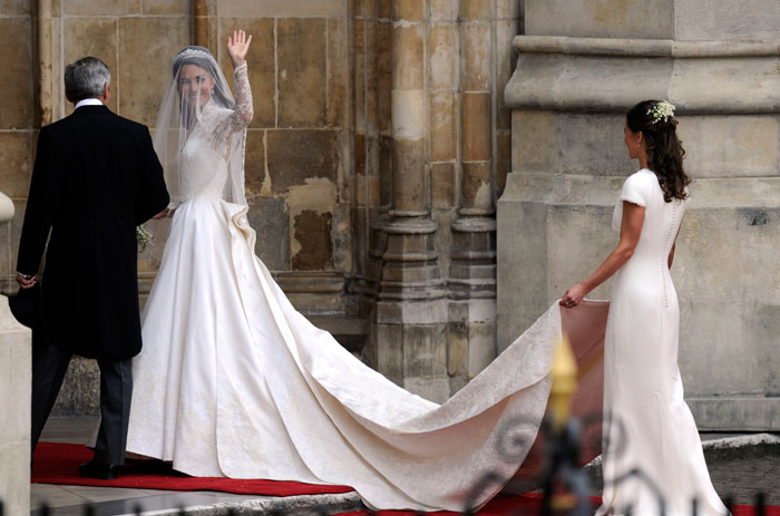 29-year-old Kate Middleton is in a full-sleeved Chantilly lace dress with a strapless slip underneath. It is full-sleeved. Commentators praised it as ?Grace Kelly-esque.? The dress has a shorter train than expected.