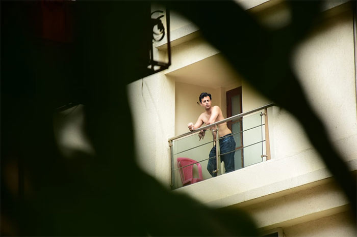 Salim Merchant was pictured on the balcony of his apartment on Monday.