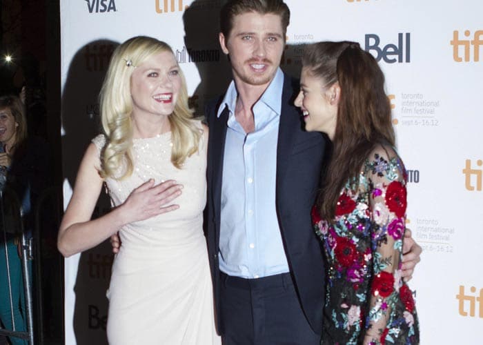 As the two ladies Kristen and Kirsten chat, Garrett Hedlund poses for the shutterbugs.