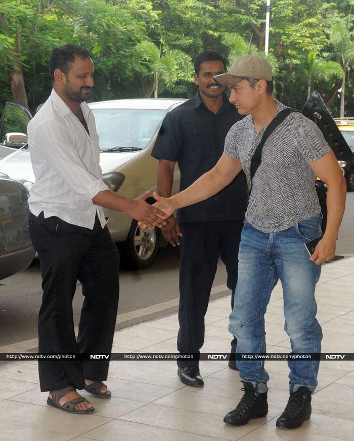 The actor shook hands with a fan he met outside the airport.<br><br>Coming up: Aamir's airport <I>Dhoom</i>