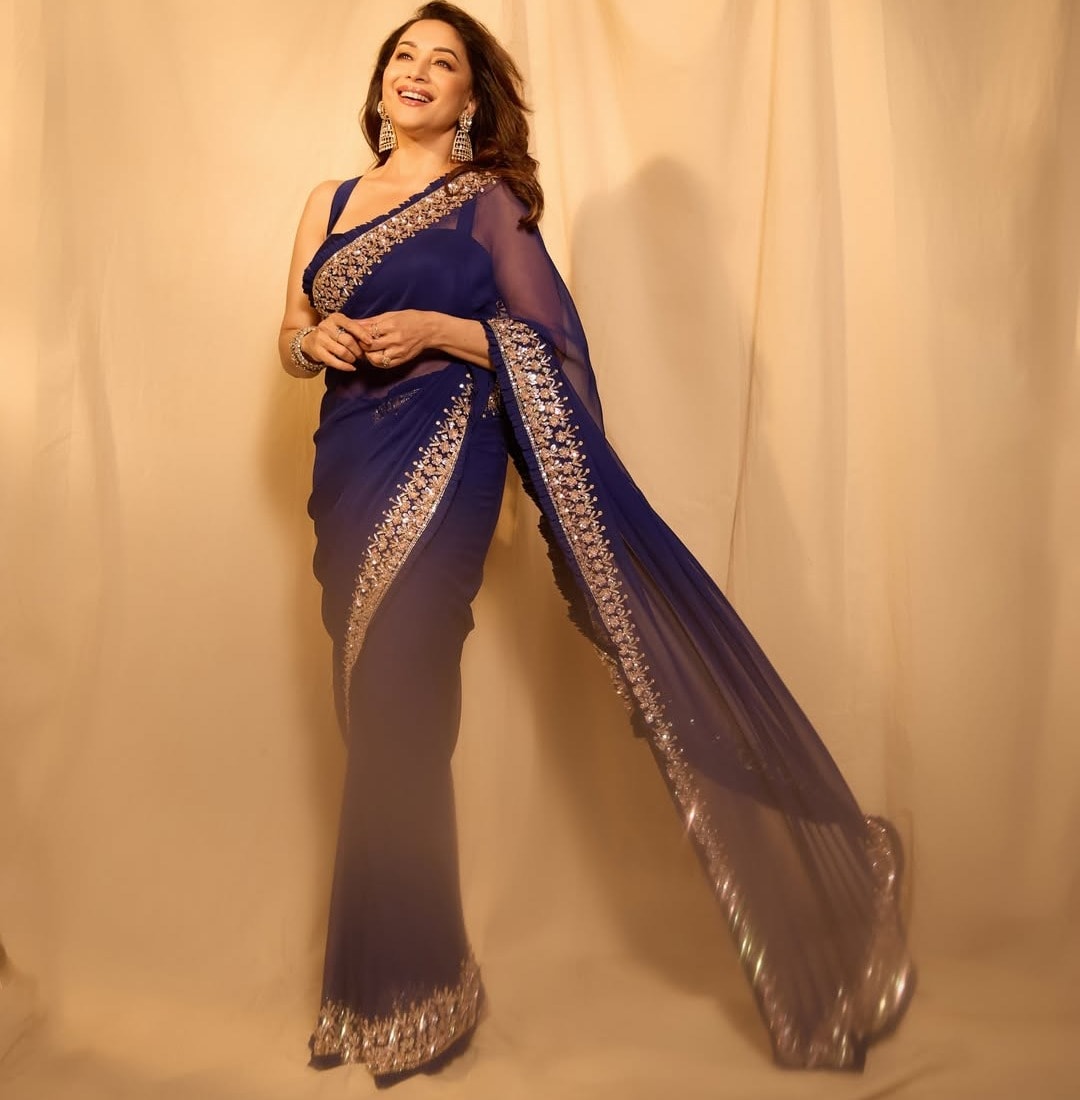 ब्लू साड़ी में माधुरी का लुक सिंपल लेकिन बहुत ही आकर्षक है. मिनिमल ज्वेलरी और न्यूड मेकअप के साथ उन्होंने इसे खूबसूरती से स्टाइल किया है. madhuridixitnene/Instagram