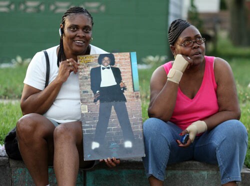 A woman holds an old record album of Pop Star Michael Jackson's outside his former childhood home. Jackson died after suffering a cardiac arrest, multiple US media outlets reported, sending shockwaves rippling across the entertainment world.