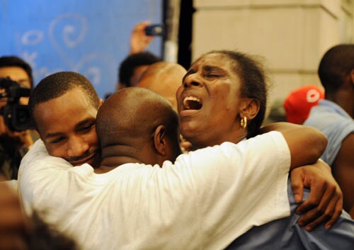 After hearing of the death of pop star Michael Jackson, three people hug as they sing songs of the late popstar.