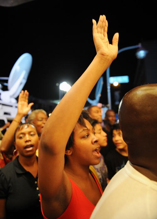 After hearing of the death of pop star Michael Jackson, people gather and sing in front of the Apollo Theater in the Harlem section of New York City.