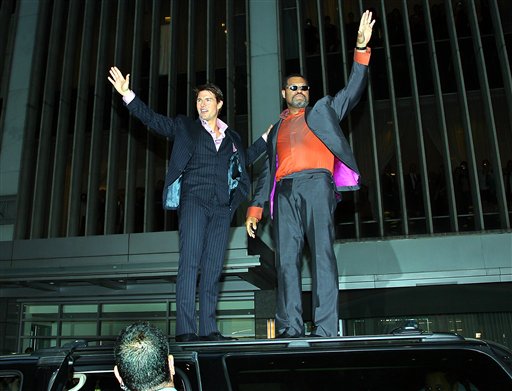 In this photo provided by Paramount Pictures,Tom Cruise and Laurence Fishburne wave to their fans from the top of a car as they arrive for the premiere of their film Mission Impossible III at the Ziegfeld Theater during the Tribeca Film Festival in New York.