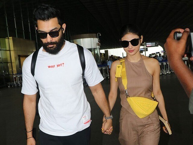 Photo : एक दूसरे का हाथ थामे एयरपोर्ट पर नज़र आए मौनी रॉय और उनके पति सूरज नांबियार