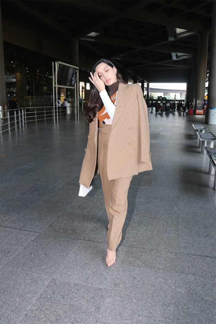 Nora Fatehi picked a brown outfit for her flight.