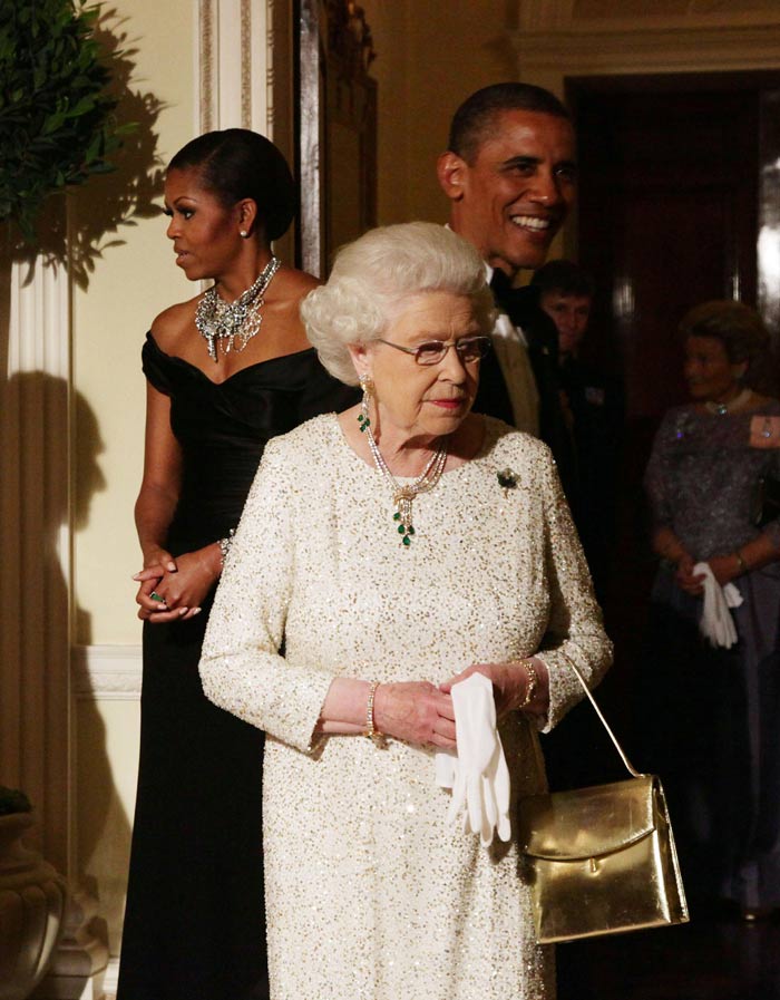 The Queen wore an Angela Kelly white evening dress with gold and silver sequins and an emerald necklace and matching earrings.