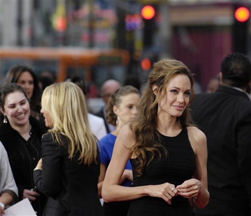 Angelina Jolie waits for Ocean's Thirteen cast member Brad Pitt to finish an interview at the premiere of the film at Grauman's Chinese Theatre in Los Angeles.