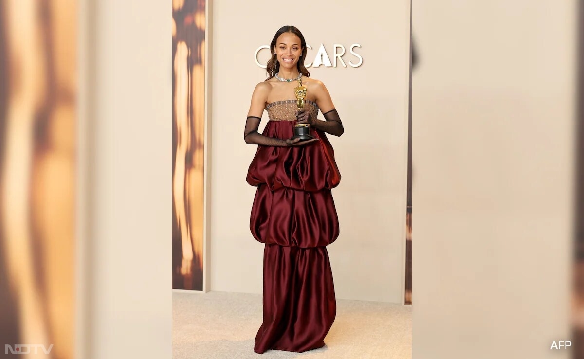 Zoe Saldana looked glamorous in a maroon puffy gown by Saint Laurent by Anthony Vaccarello. (Image Courtesy: AFP)