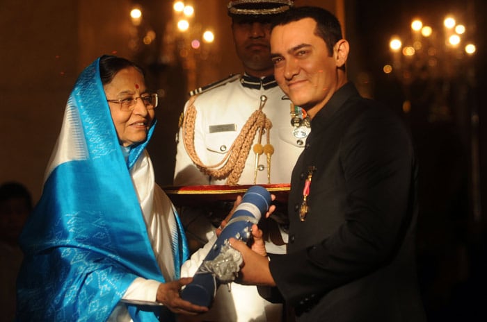 Indian President Prathiba Singh Patil (L) presents The Padma Bhushan Award to Indian cinema actor Amir Khan during the presentation of the 'Padma Awards 2010' at The Presidential House in New Delhi on March 31, 2010. Indian President Pratibha Patil presented 66 Padma Vibhushan and Padma Sri and Padma Bhushan awards to personalities from different professional backgrounds for their contribution to the nation.   AFP PHOTO/RAVEENDRAN