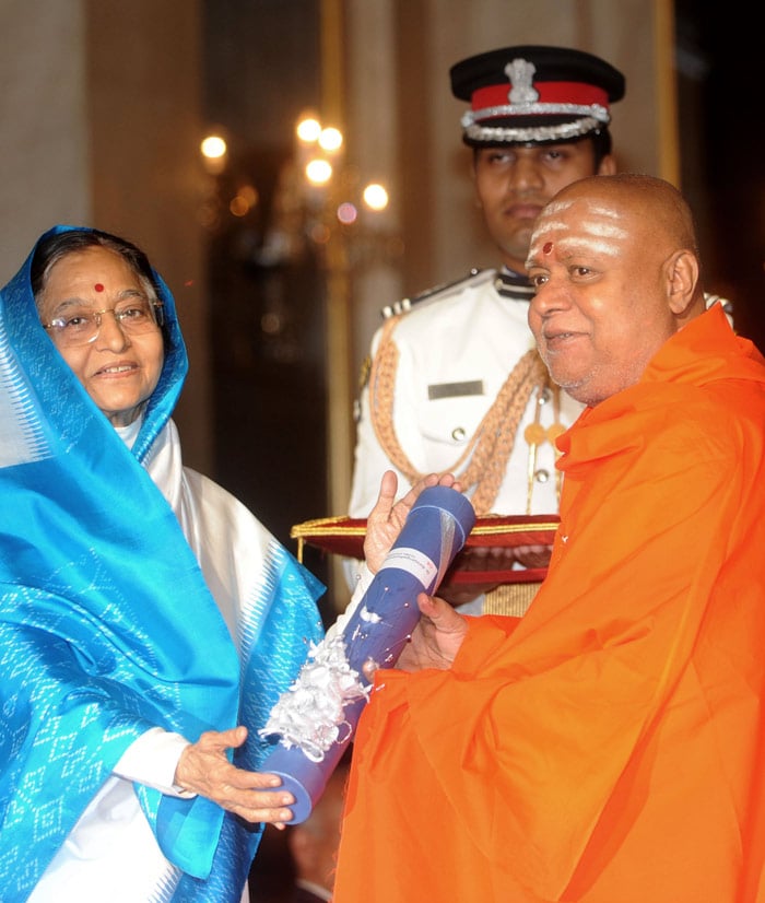 Indian President Prathiba Singh Patil (L) presents The Padma Bhushan Award to Balagangadharanatha Swamji, the 71st Pontiff of the religious centre of the Sri Adichunchanagiri Mahasamsthana Math, Karnataka, during the presentation of the 'Padma Awards 2010' at The Presidential House in New Delhi on March 31, 2010. Indian President Pratibha Patil presented 66 Padma Vibhushan and Padma Sri and Padma Bhushan awards to personalities from different professional backgrounds for their contribution to the nation.   AFP PHOTO/RAVEENDRAN