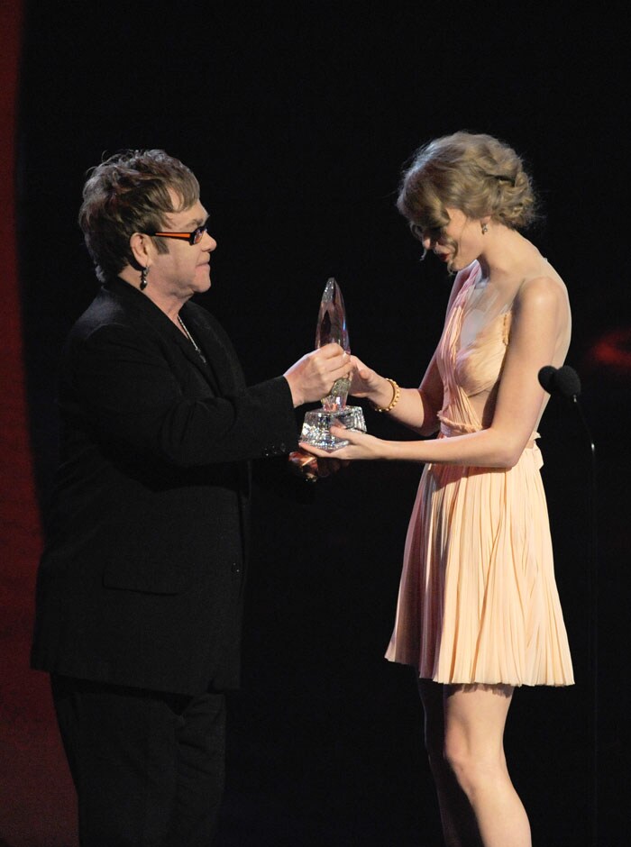 Taylor Swift is handed her award for Favourite Country Artist by pop legend Elton John.