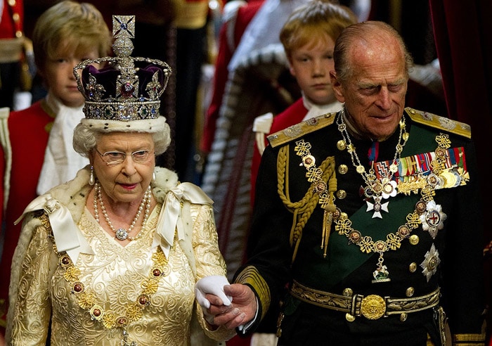 Britain's Queen Elizabeth II holds the hand of her husband Prince Philip, as she arrives to address to the House of Lords, during the State Opening of Parliament in Westminster, central London on May 25, 2010. Queen Elizabeth II set out the new coalition government's legislative programme on Tuesday in a ceremony of pomp and history following the closest general election for decades. (Photo: AFP)