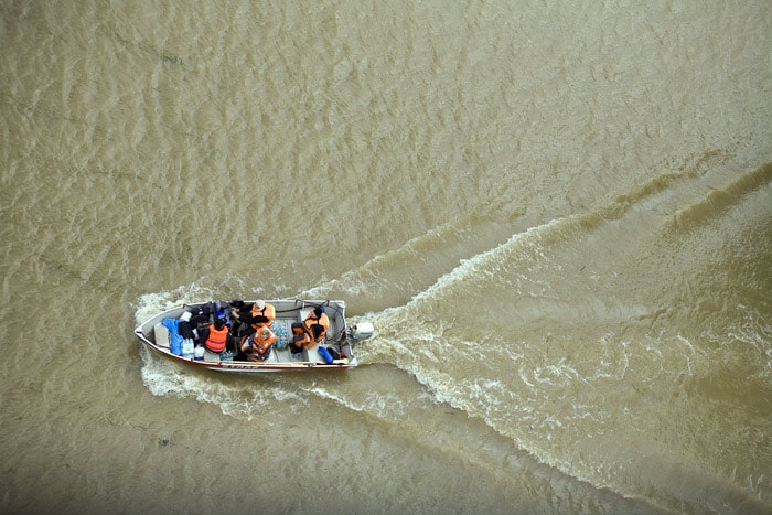 Polish firemen deliver food by boat to people in the flooded area of Swiniary village, in central Poland, near the Wisla river on May 25, 2010. Floods caused by torrential rains last week have swollen major Polish rivers to their highest levels in more than a century and have claimed 15 lives. (Photo: AFP)