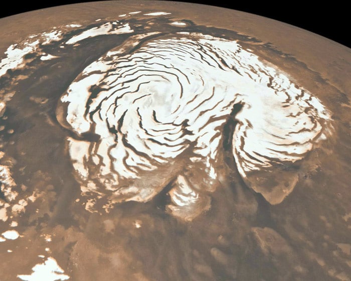 This May 27, 2010 NASA image, combining data from two instruments aboard NASA's Mars Global Surveyor, depicts an orbital view of the north polar region of Mars. The ice-rich polar cap (the quasi-circular white area at center) is approximately 1,000 kilometers across. The white cap is riven with dark, spiral-shaped bands. (Photo: AFP)