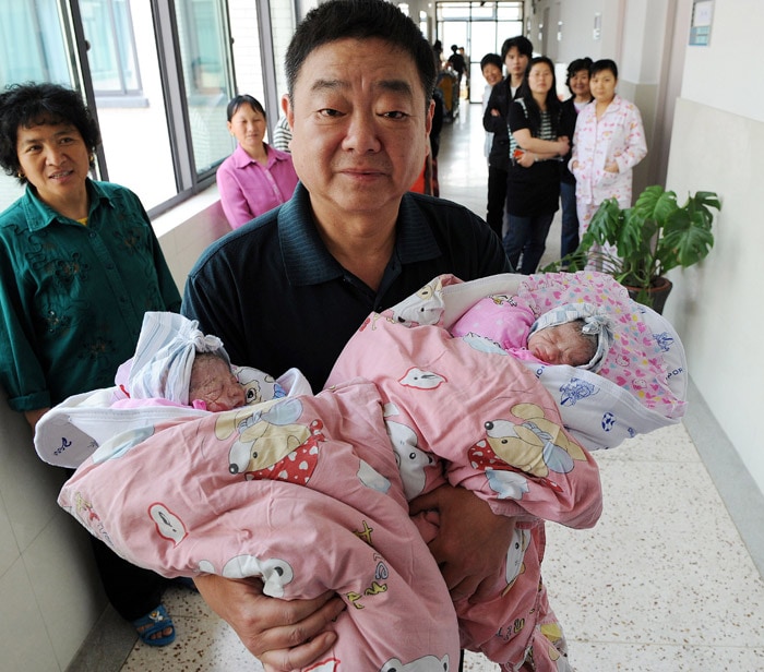 Wu Jingzhou carries his twin daughters after his sixty-year-old wife, only referred to by her pseudonym Cheng Lin, gave birth at a hospital in Hefei, east China's Anhui province on May 25, 2010. Cheng, received in vitro fertilisation, after losing her daughter Tingting, who died in a gas poisoning accident in 2009, making her the oldest woman to give birth in the Asian nation. (Photo: AFP)