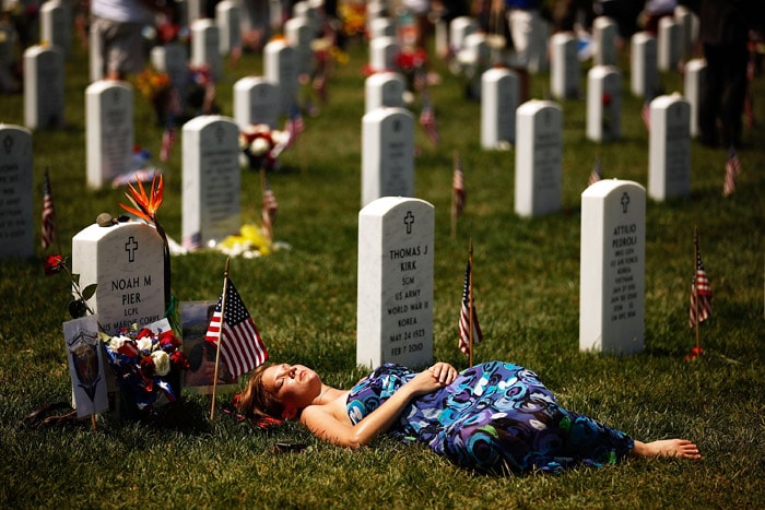 A young woman lays down on the grave of US Marine Corps Lance Corporal Noah Pier on Memorial Day at Arlington National Cemetery on May 31, 2010 in Arlington, Virginia. Pier was killed on Feburary 12, 2010 in Marja, Afghanistan. This is the 142nd Memorial Day observance at the cemetery. (Photo: AFP)