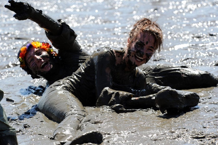 Participants of the so-called 'Wattoluempiade' Tidelands Olympics lay in the mud on June 6, 2010 in Brunsbuettel, northern Germany. About 500 mud enthusiasts compete in different disciplines such as mudflat volleyball or mudflat handball. (Photo: AFP)