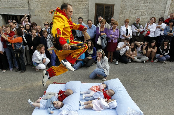 A man dressed up as the devil jumps over babies lying on a mattress in the street during the 'El Salto del Colacho' (the jump of the devil) to mark the Corpus Christi feast in Castrillo de Murcia, near Burgos, on June 6, 2010. (Photo: AFP)