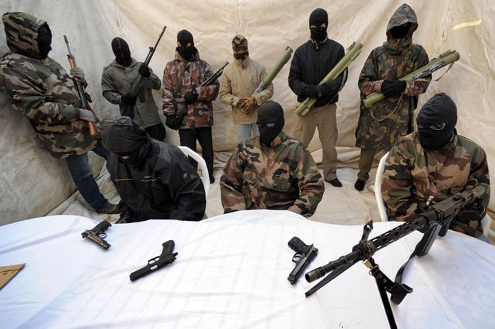 Hooded and clad in military fatigues, armed with guns, rocket launchers, members of a commando claiming to belong to the National Liberation Front of Corsica answer media questions at a press conference held near Ajaccio in May 2010. The outlawed military  branch of the Corsican nationalists FNLC said in an interview due to be released on June 3, 2010 that they 'will carry on their armed struggle, against the colonial policy of France'. (Photo: AFP)