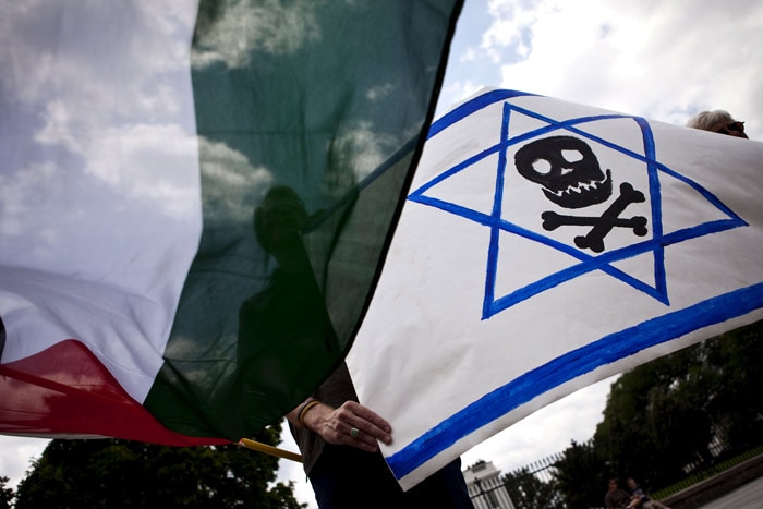 Eric Anderson, of Washington, flies a Palestinian flag and an Israeli flag with a skull and crossbones on it during a protest in front of the White House in Washington, on Tuesday, June 1, 2010, against Israel's raid on a flotilla of aid ships heading to the Gaza Strip. (Photo: AP)