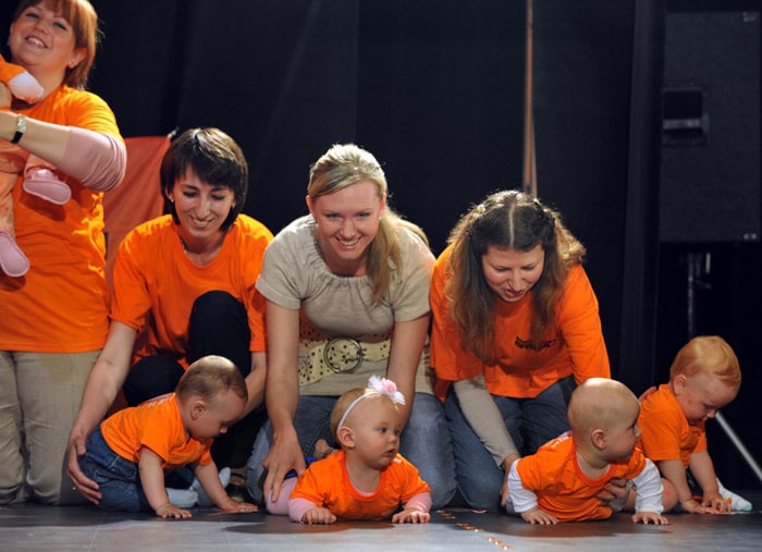 Ukrainian mothers hold their babies, in the one year-old category, in a starting position before the crawling run during a Baby Drive competition in Kiev on May 31, 2010. Dozens of babies will crawl the four-meter distance on all fours during the International Children's Day celebrated on June 1, 2010. (Photo: AFP)