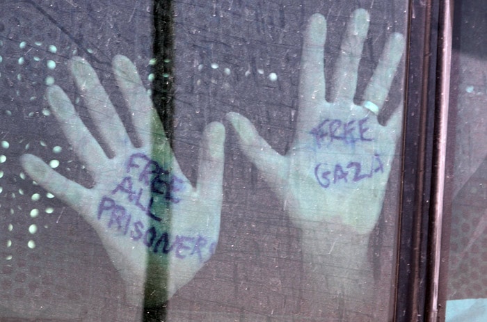 Detained activists from the Gaza-bound flotilla which was stopped by the Israeli navy during a deadly raid, place their hands on a bus window transporting them from a prison in the southern Israeli city of Beersheva to Ben Gurion airport near Tel Aviv, on June 2, 2010, on their way to be deported to their home countries.  (Photo: AFP)