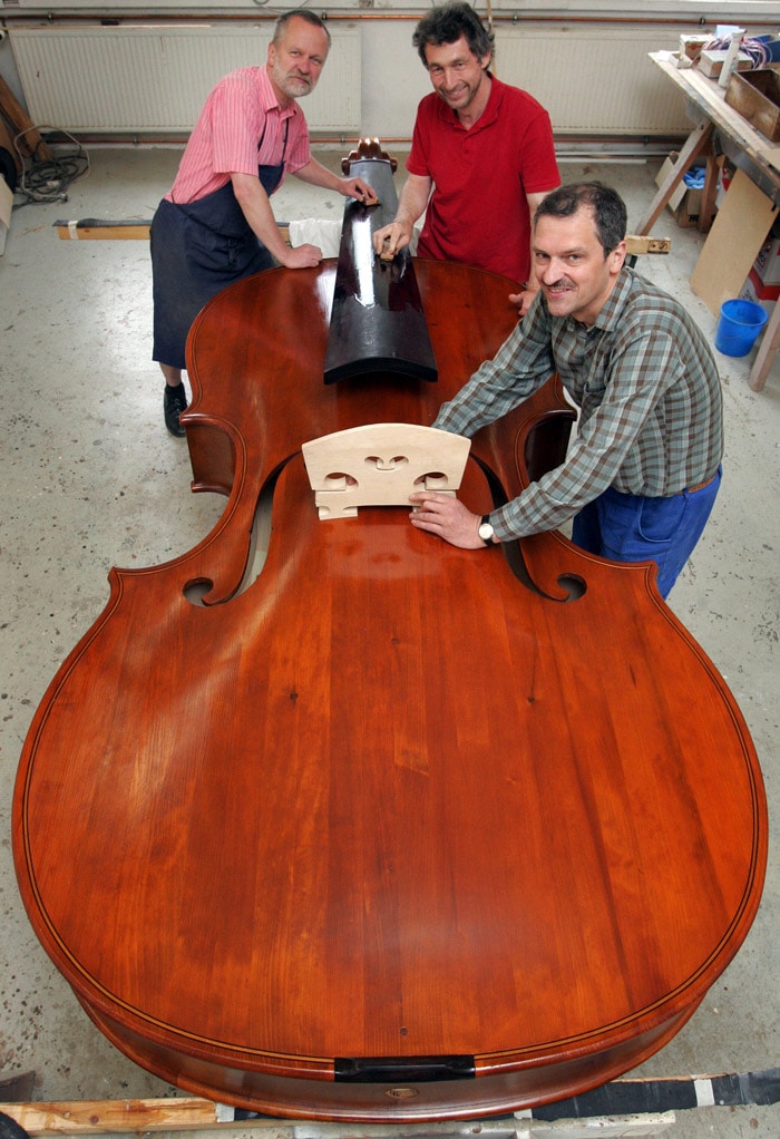 Luthiers (L-R) Udo Kretzschmann, Ekkard Seidl and Frank Schlegel work on the world's allegedly biggest playable violin on May 31, 2010 in Markneukirchen, eastern Germany. Twelve luthiers of the region known for its violin making tradition are building the instrument which is 4,28 meters tall, 1,45 meters large and has a weight of more than 100 kilograms. (Photo: AFP)