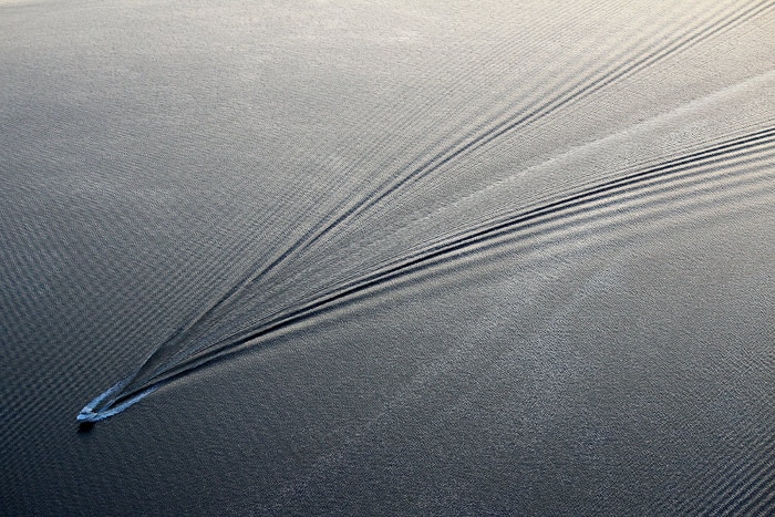 A speedboat races through a sheen of oil June 2, 2010 south of Biloxi, Mississippi. Oil believed to be related to the Deepwater Horizon accident began to appear on June 1 on the shores of Alabama and Mississippi. (Photo: AFP)