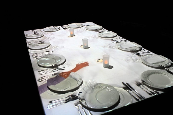 A new multimedia art exhibition entitled 'In Other People's Skins' by British artist Terry Flaxton is shown at the Cathedral of St. John the Divine on June 3, 2010 in New York City. The exhibit, which is housed under a black tent inside the historic church, features a table surrounded by chairs with an overhead projector beaming life-size images of hands and arms enjoying a meal. Inspired by Leonardo Da Vinci's 'The Last Supper', 'In Other People's Skins' looks to celebrate different cultures and the daily act of eating with others. (Photo: AFP)