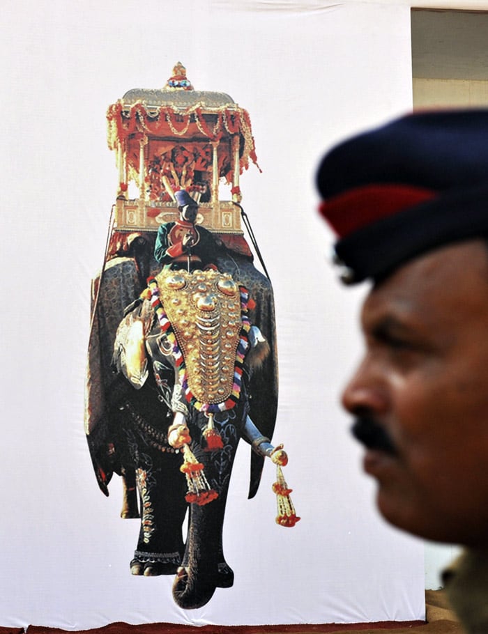 A policeman walks past a promotional billboard at the Global Investors' Meet 2010 venue in Bangaluru on June 2, 2010. (Photo: AFP)