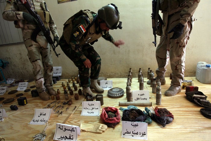 Iraqi soldiers display materials used for making bombs they found at the house of a man who allegedly makes them in the area of Sabaa al-Bor, north of Baghdad, on June 2, 2010 after the suspect who was wearing an explosive belt blew himself up when security forces surrounded his house. (Photo: AFP)