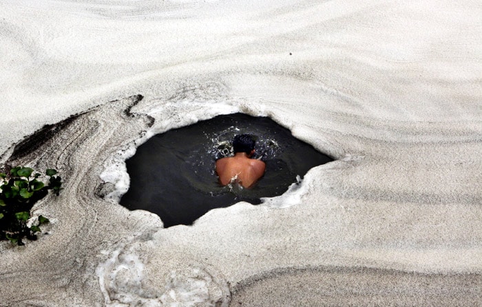 A boy takes a dip in the river Yamuna with froth from industrial pollution floating on the surface, in New Delhi, on Saturday, June 5, 2010. World Environment Day 2010 being marked on Saturday calls for an urgent need to conserve the diversity of life on earth. (Photo: AP)