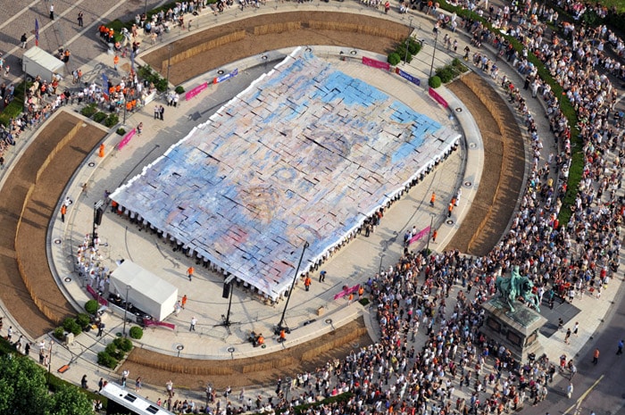 1,250 people, each holding a piece of a reproduction of a painting by Monet, gathered to form a gigantic living impressionist painting in Rouen, on June 5, 2010. This short lived creation baptised 'Monet seen from the sky' occupied 600m2 of the Town hall square closed for the occasion. (Photo: AFP)