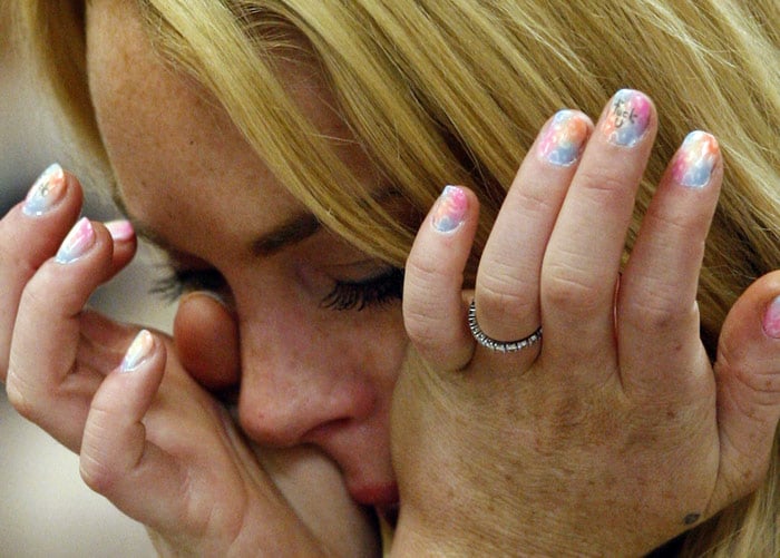 Lindsay Lohan cries as she is sentenced to 90 days jail by Judge Marsha Revel during her hearing at the Beverly Hills Courthouse on July 6, 2010. She sobbed and pleaded in court not to be thrown in jail, but troubled Hollywood starlet Lindsay Lohan had another, far less plaintive message for the judge, written on the fingernail of her middle finger. Photographers using telephoto lenses captured photos showing that Lohan, hand pressed against her mouth, had the words "f**k u" carefully written over a multicolored pastiche of pastel nail polish (Middle Finger-R). The judge ordered Lohan, 24, to spend 90 days in jail for violating probation in two 2007 drunken driving cases. She also was ordered to take part in a 90-day in-patient substance abuse program. (Photo: AFP)