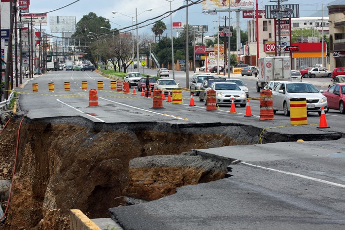 Cars drive in a road damaged by the overflowing of the Santa Catarina river, during heavy rains due to Hurricane Alex, in Monterrey, Nuevo Leon state, Mexico,on July 7, 2010. The rains in the wake of Hurricane Alex, which left 15 dead in northern Mexico, and a new system of rain on Wednesday caused the evacuation of 25,000 people and the closure of an international bridge with the United States, officials said. (Photo: AFP)